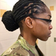 Staff Sgt. Chaunsey Logan demonstrates how her locs adhered to the Army’s revised grooming standards once twisted into a bun. When untwisted, Logan’s dreadlocks were considered not in compliance. The Army’s ban on dreadlocks—enforced since 2005—will come to an end in 2018. (Courtesy of Chaunsey Logan)